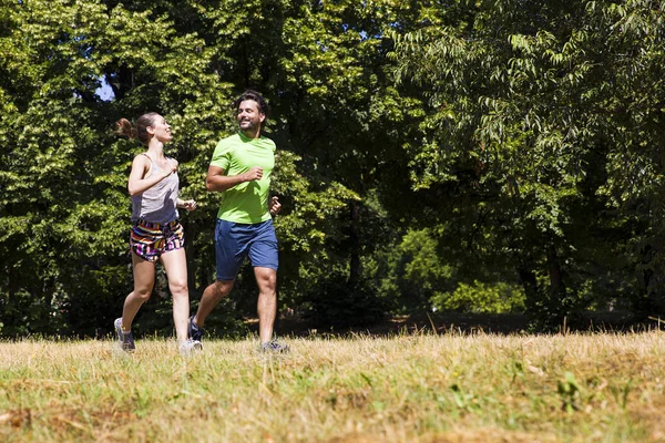 Jovem casal correndo no parque — Fotografia de Stock