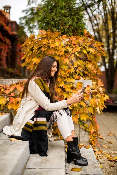 Femme avec téléphone dans le parc d'automne — Photo