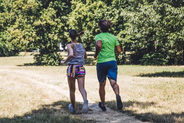 Pareja joven corriendo en el parque — Foto de Stock