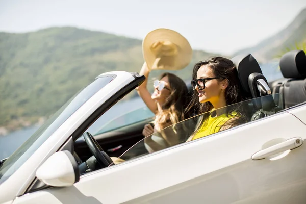 Jonge vrouwen in wit cabriolet auto — Stockfoto