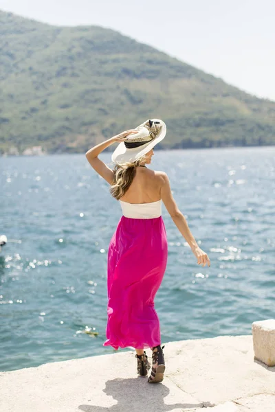 Jovem mulher atraente posa junto ao mar — Fotografia de Stock