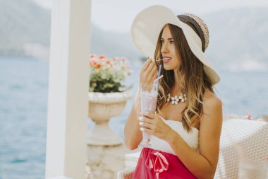 Denizin kenarında genç çekici kadın pozlar