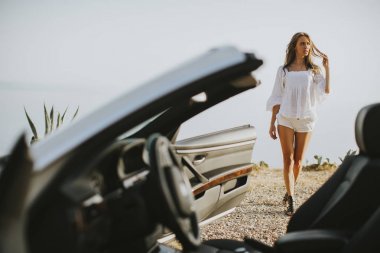 Genç ve güzel kadın beyaz cabriolet tarafından