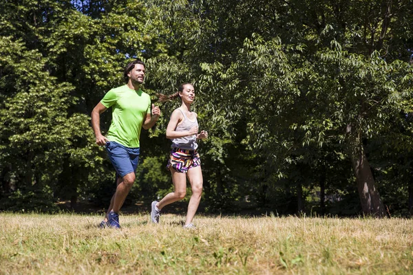 Pareja joven corriendo en el parque — Foto de Stock