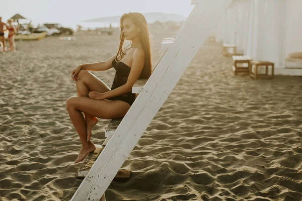 Jonge vrouw die zich voordeed op het strand — Stockfoto