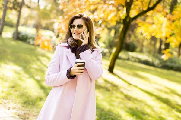 Elegant young woman walking in the autumn park — Stock Photo, Image