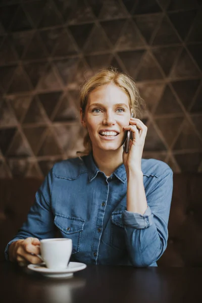 Mujer bastante joven con teléfono móvil en la cafetería — Foto de Stock