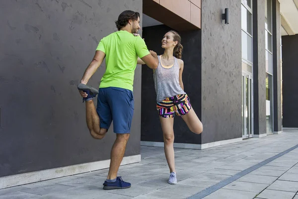 Mujer atractiva joven haciendo ejercicio con un entrenador personal — Foto de Stock