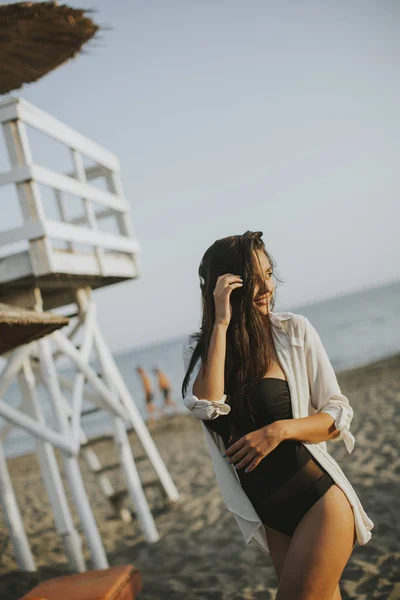 Jonge vrouw die zich voordeed op het strand — Stockfoto