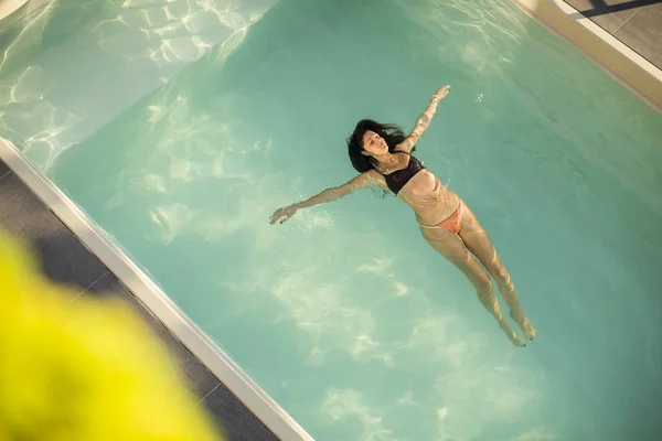 Jonge vrouw in het buitenzwembad — Stockfoto