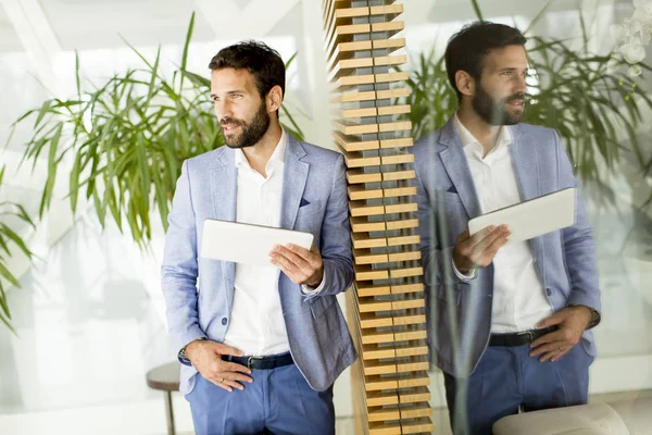 Sourire jeune homme d'affaires en utilisant sa tablette numérique — Photo