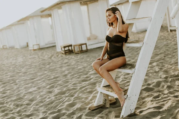 Mujer yung bonita sentada en la playa —  Fotos de Stock