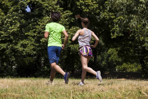 Giovane coppia che corre nel parco — Foto Stock