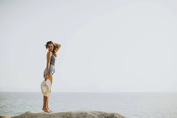 Красивая молодая женщина на каменистом берегу — стоковое фото