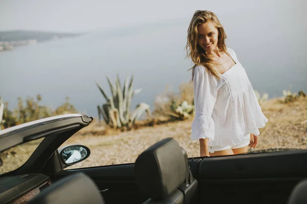 Hübsche junge Frau im weißen Cabrio — Stockfoto