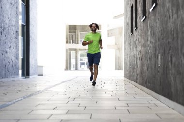 Kentsel çevre sokakta koşan genç adam