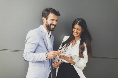 Genç iş çift duvar tarafından tablet üzerinde çalışan