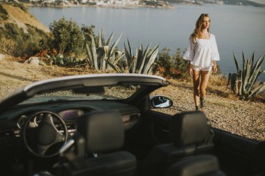 Beyaz cabriolet araba ile genç ve güzel kadın
