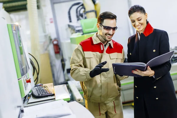 Mujer joven proceso de control en la fábrica con trabajador masculino — Foto de Stock