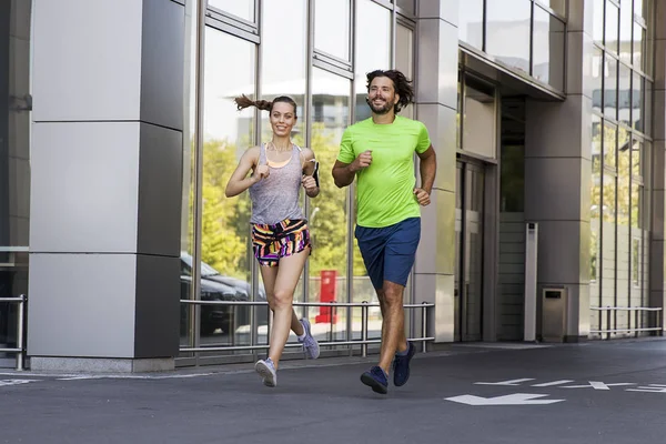 Bonito homem e bela mulher correndo juntos — Fotografia de Stock