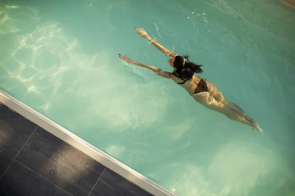 Mulher de biquíni flutuando na água na piscina — Fotografia de Stock