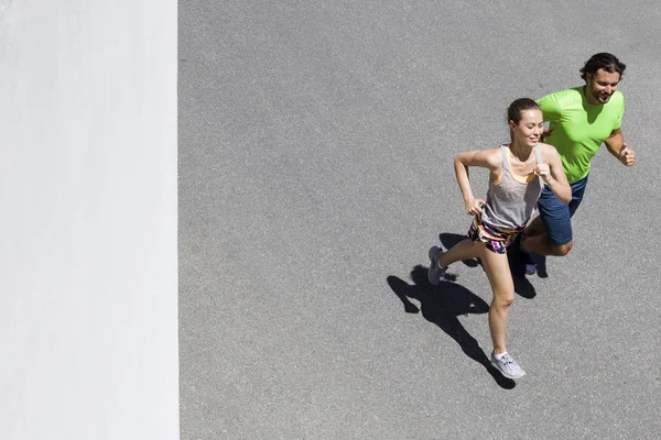 Hombre guapo y hermosa mujer corriendo juntos — Foto de Stock