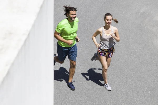 Knappe man en mooie vrouw samen joggen — Stockfoto