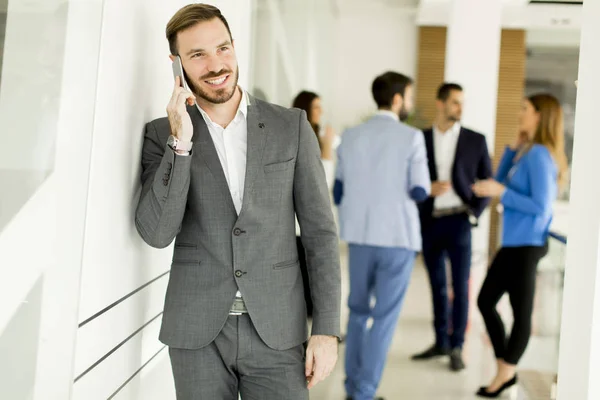 Affärsman med mobiltelefon på kontoret — Stockfoto