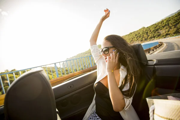 Kvinnan använder mobiltelefon och lokalisering i cabriolet på sommardag — Stockfoto