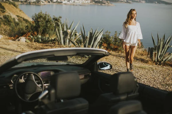 Beyaz cabriolet araba ile genç ve güzel kadın
