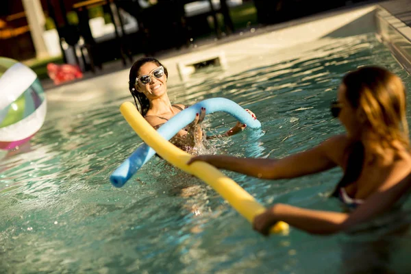 Młode kobiety, zabawy w basenie — Zdjęcie stockowe