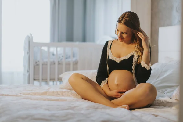 Kobieta w ciąży na łóżku — Zdjęcie stockowe
