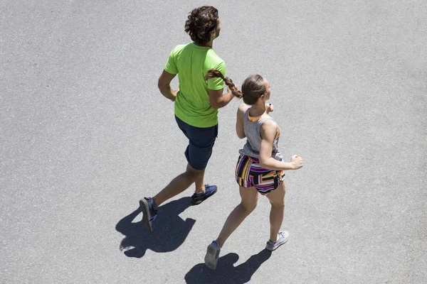 Pohledný muž a krásná žena společně zaběhat na ulici — Stock fotografie