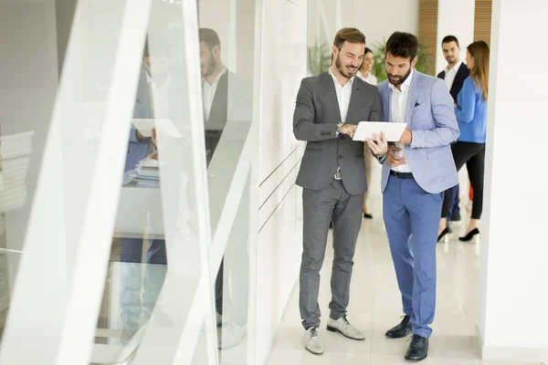 Deux hommes d'affaires avec une tablette dans le bureau — Photo