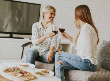 Genç kadın pizza yemek güzel ve kırmızı şarap içmek