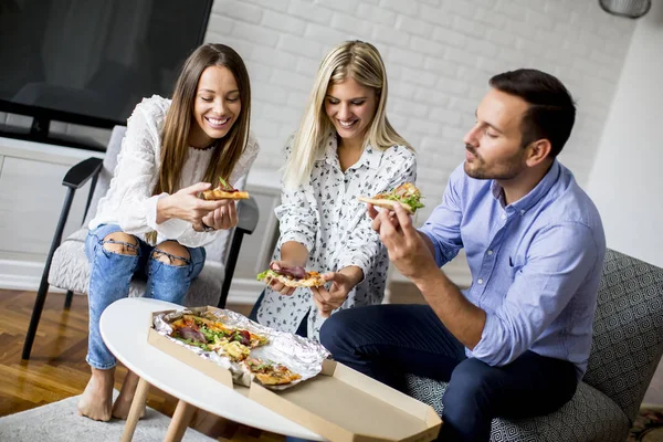 Jóvenes amigos comiendo pizza en la habitación — Foto de Stock