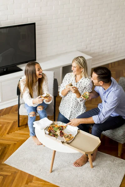 Giovani amici che mangiano pizza in camera — Foto Stock