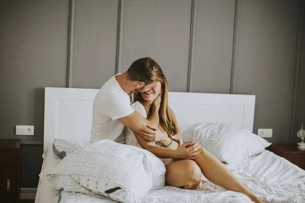 Schönes junges Paar küsst sich im Bett — Stockfoto