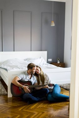 Yerde gitar çalan romantik bir çift.