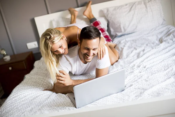 Intim szerelmesek használ laptop az ágyon — Stock Fotó