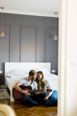 Yerde gitar çalan romantik bir çift.