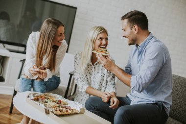 Genç arkadaşlar odaya pizza yemek