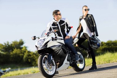 Giyen kadın ve erkek deri ceket ve şık güneş gözlüğü kurtulmak