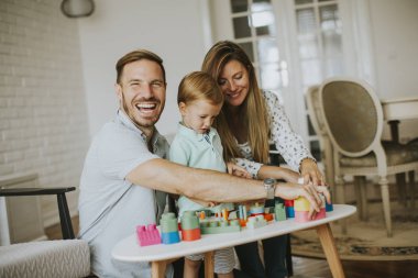 Küçük çocuk annesi ve babası evde oyuncaklarla oynamak