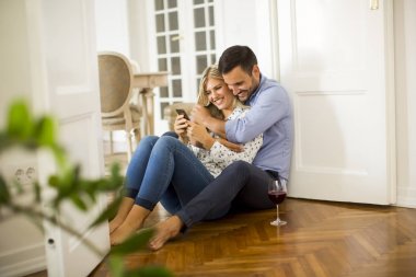 Genç bir çift kırmızı şarap içme yere oturur 