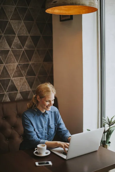 Ung kvinna sitter i café, dricka kaffe — Stockfoto