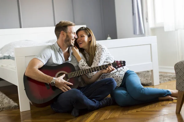 Yerde gitar çalan romantik bir çift.