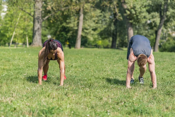 Genç çift parkta egzersiz sahip