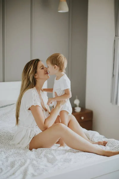 Mãe brincando com o menino na cama — Fotografia de Stock