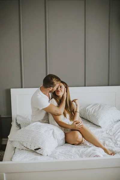 Mooie jonge paar zoenen in het bed — Stockfoto